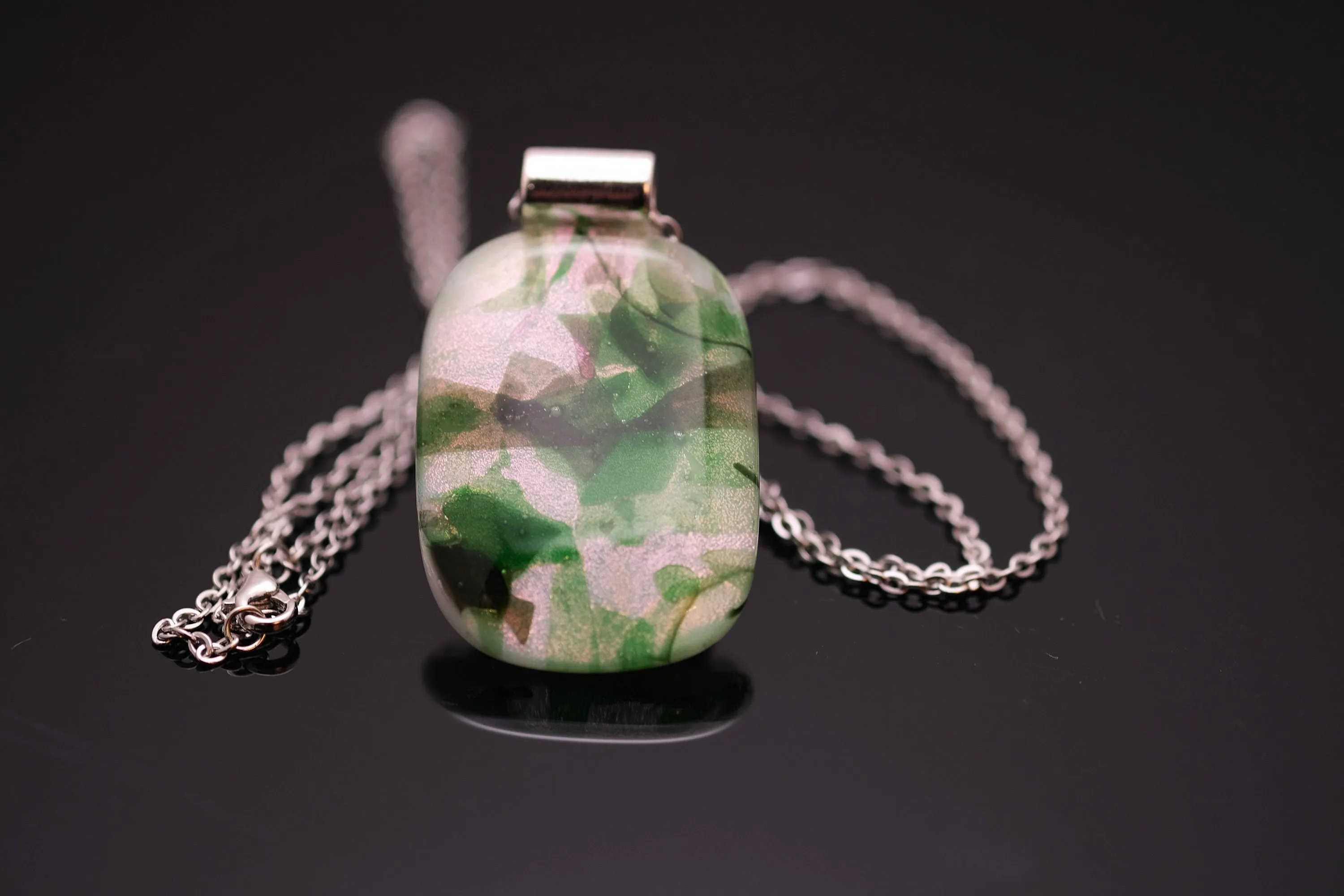 Dichroic green floral on white fused glass statement pendant necklace on 24 inch steel chain. 1.75 x 1 inch pendant