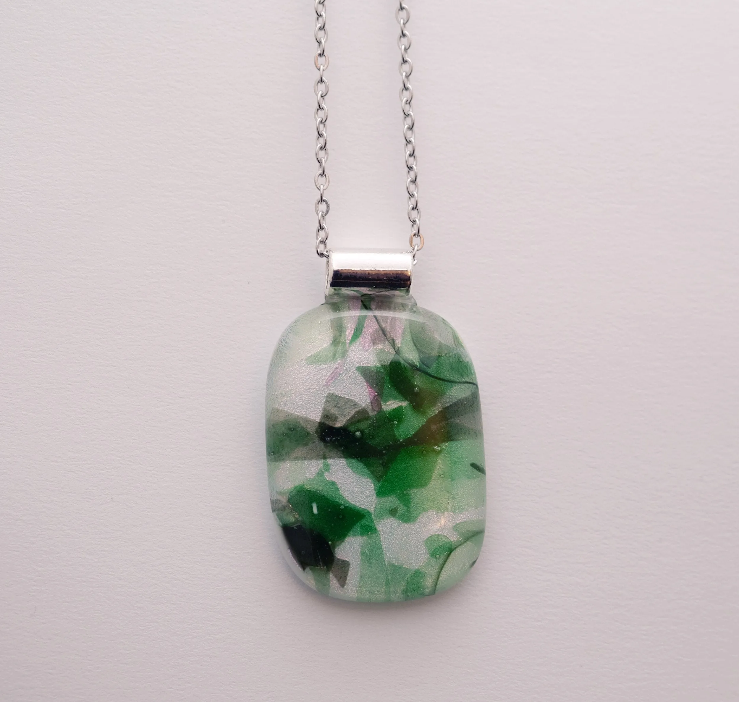 Dichroic green floral on white fused glass statement pendant necklace on 24 inch steel chain. 1.75 x 1 inch pendant